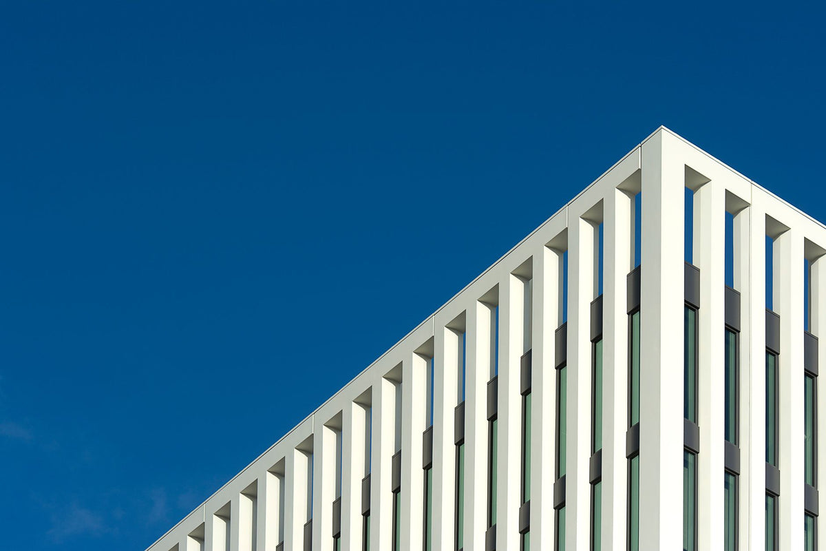 A contemporary white building facade with clear blue sky in Den Haag, perfect for architectural themes.