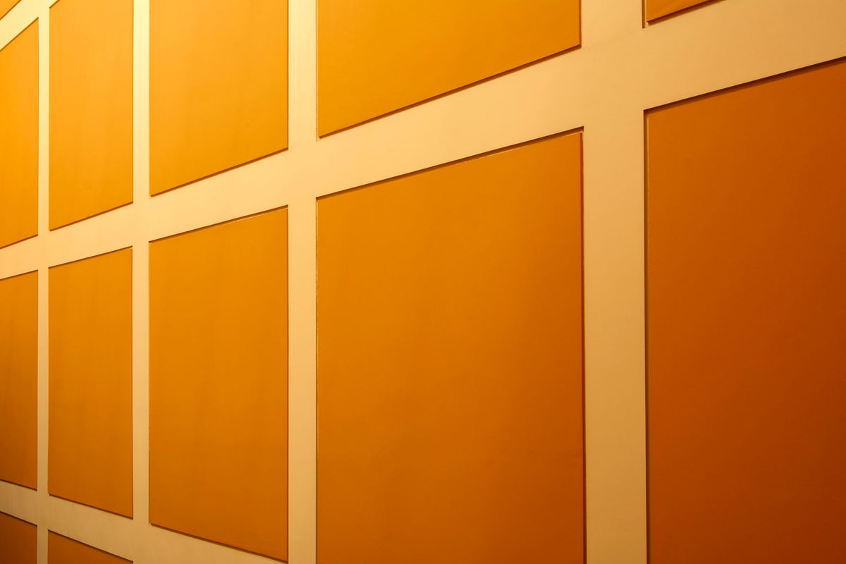 Abstract view of a bright orange wall with geometric patterns, ideal for backgrounds.