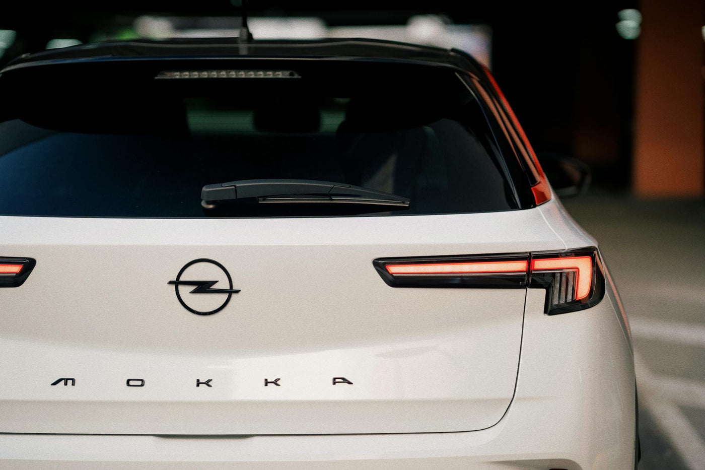 Close-up rear view of a white Opel Mokka in a garage setting, highlighting modern design.